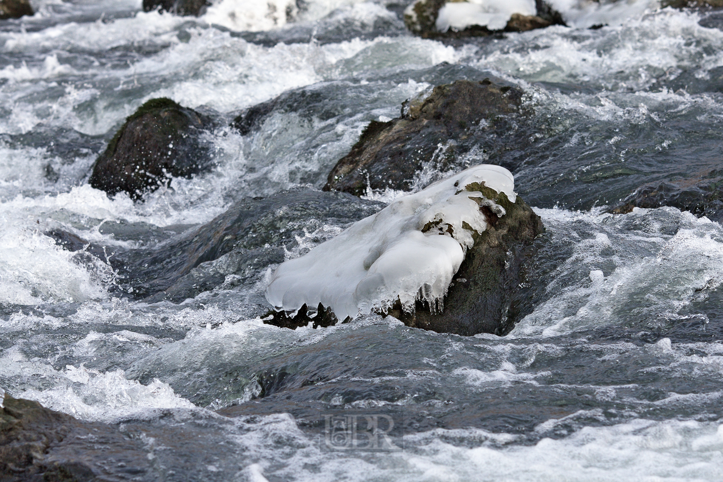 Eisfigurentheater auf Steinen und Felsblöcken im Fluss